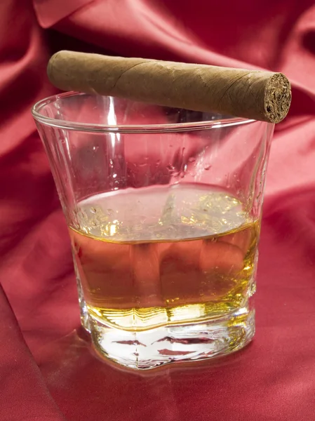 Whisky et cigare sur satin rouge — Photo