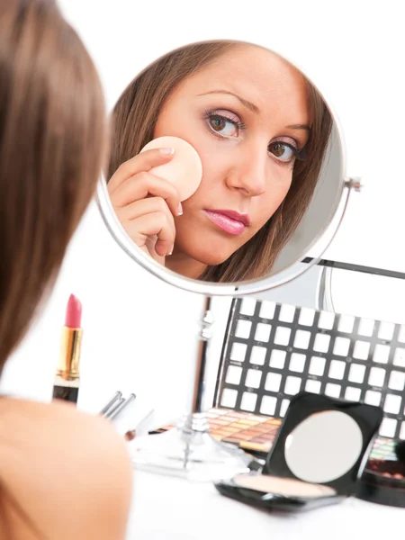 Tillämpar make-up på ung kvinna ansikte — Stockfoto