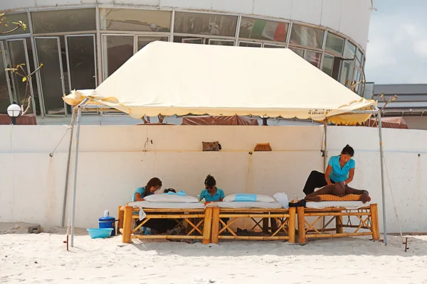 Tourist receiveing beach massage — Stock Photo, Image