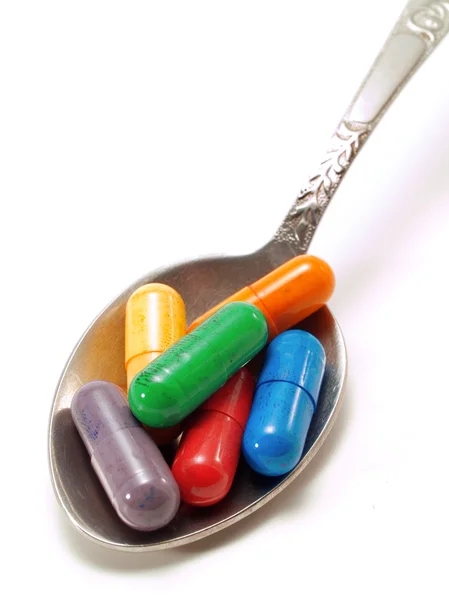 Красочные таблетки в ложке — стоковое фото