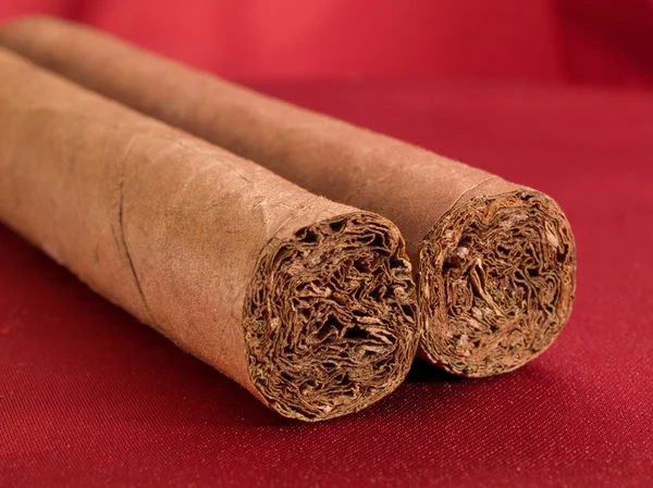 Dos cigarros en satén rojo —  Fotos de Stock
