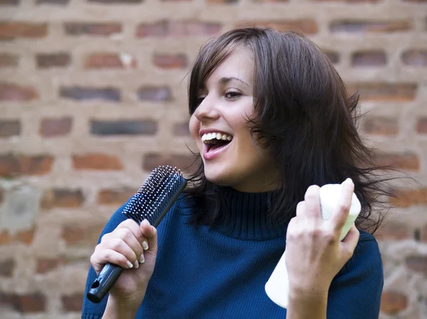 Morena tousle-headed fingindo cantar — Fotografia de Stock