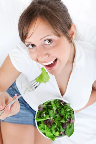 Jovem mulher comendo salada — Fotografia de Stock