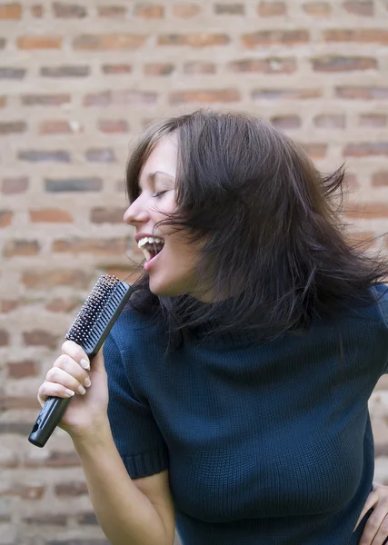 Chica cantando en su cepillo de pelo —  Fotos de Stock