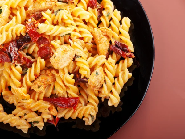 Fusilli with chicken and dried tomatoes — Stock Photo, Image