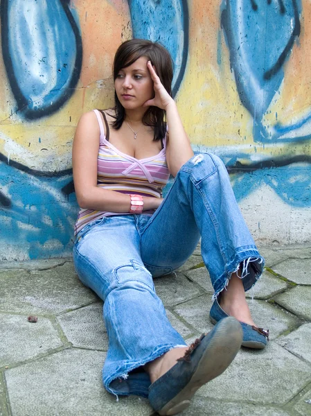 Girl in front of grafitti wall — Stock Photo, Image