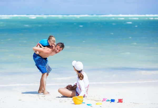 Família feliz jogando na praia — Fotografia de Stock