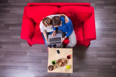 Genç çift dizüstü bilgisayar kullanıyor