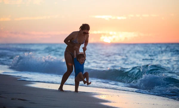 Mother and son on sunset beach — Stock Photo, Image