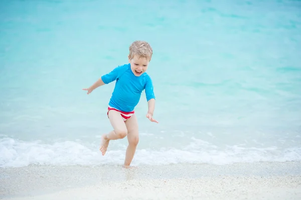 Boy running in breaking waves — Stock Photo, Image