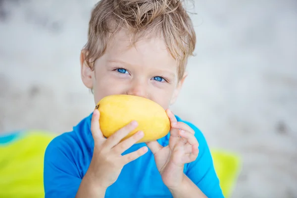 Lindo niño con fruta de mango — Foto de Stock