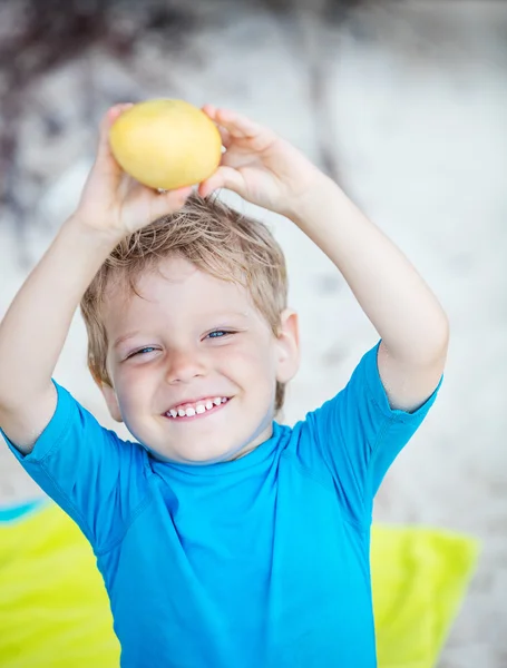 Симпатичный маленький мальчик с фруктами манго — стоковое фото