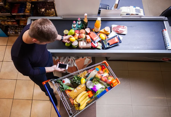 Mladý muž v supermarketu — Stock fotografie