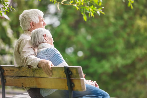 高齢者のカップルがベンチで休んで — ストック写真