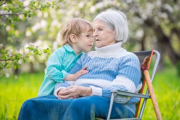 Junge erzählt seiner Großmutter ein Geheimnis — Stockfoto