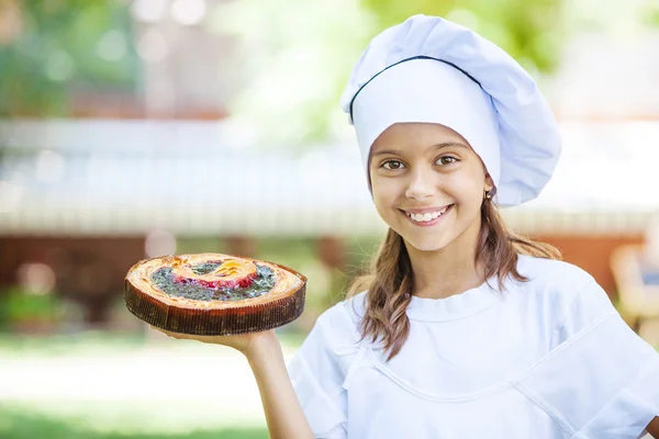 Szef kuchni dziewczynka gospodarstwa pie — Zdjęcie stockowe