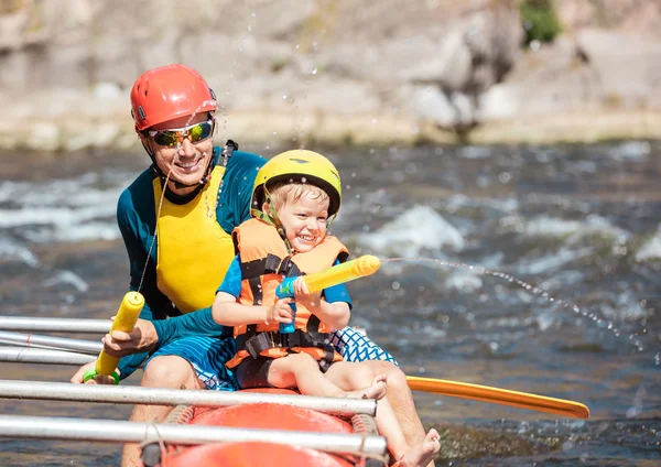 Père et fils jouant avec des pistolets à eau — Photo