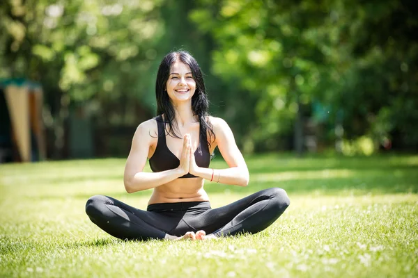 Sorridente donna seduta in posizione loto — Foto Stock