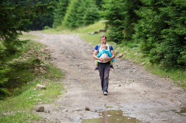 Uyuyan oğlunu taşıyan beyaz adam 
