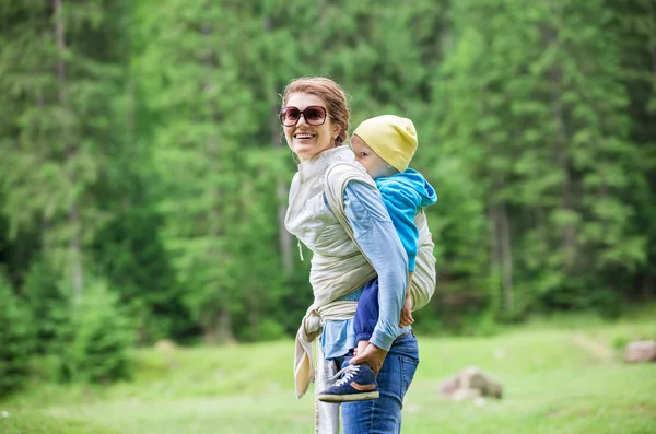 Mujer joven llevando a su hijo pequeño —  Fotos de Stock