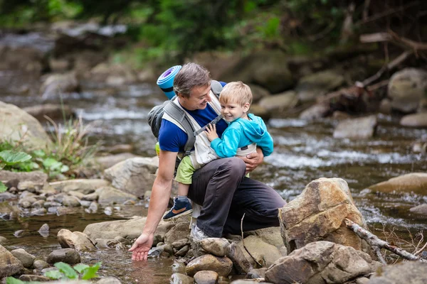 Homme touchant l'eau dans les montagnes rivière — Photo