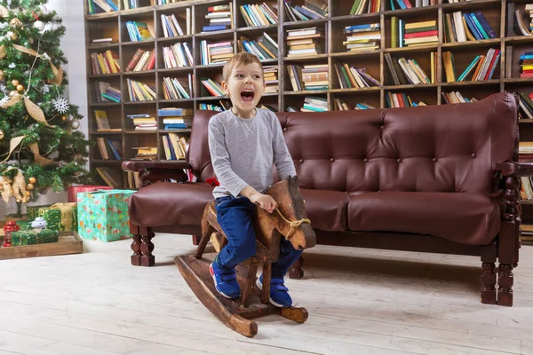 Niño Preescolar Feliz Caballo Mecedora Madera Con Árbol Navidad Fondo — Foto de Stock