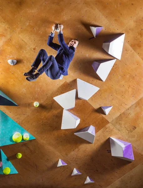 Mladý Muž Obleku Leze Obtížnou Cestou Umělé Zdi Boulderingové Tělocvičně — Stock fotografie