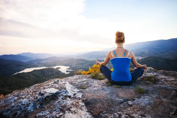 Mujer joven sentada en una roca y disfrutando de la vista del valle —  Fotos de Stock