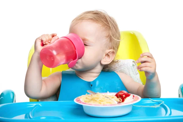 Kleine jongen drinkwater zittend aan tafel — Stockfoto