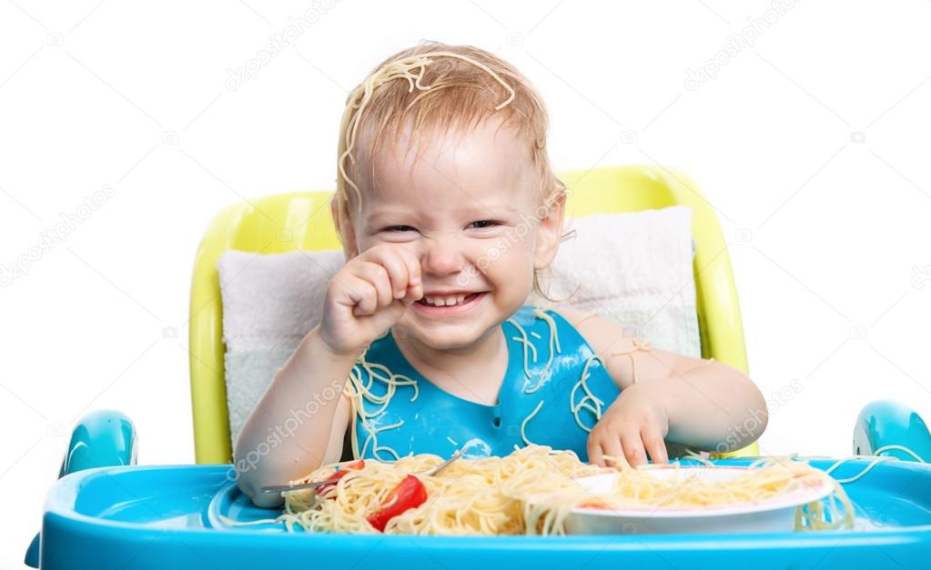 Little boy eating spaghetti with pasta on his head — Stock Photo