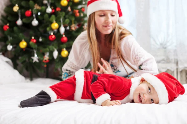 Jovem mãe brincando com bebê vestido com traje de Santa — Fotografia de Stock