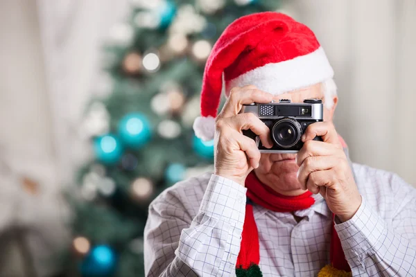 Homme âgé prenant des photos sur fond de Noël — Photo