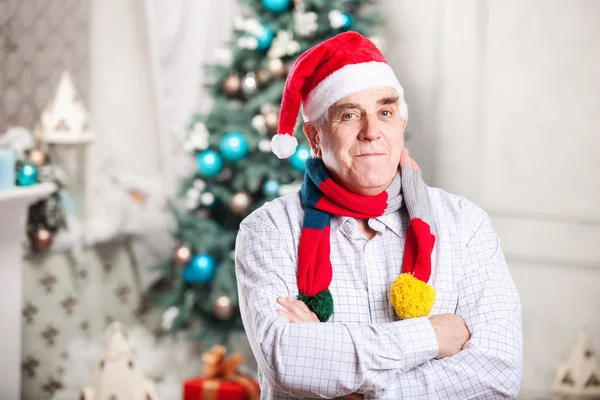 Senior homme dans le chapeau du Père Noël sur fond de Noël — Photo