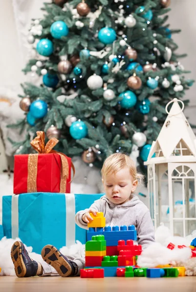 Ragazzo bambino carino che gioca con i blocchi di costruzione all'albero di Natale — Foto Stock