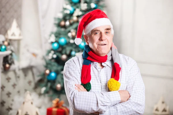 Senior man in Santa's hat on Christmas background — Stock Photo, Image