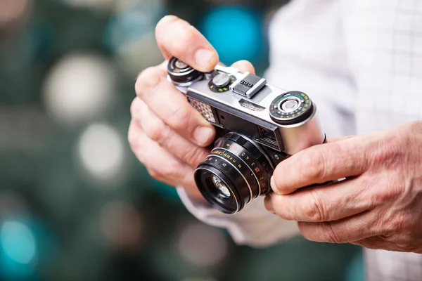 Cropped view of man holding retro camera against Christmas background — Stock Photo, Image