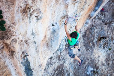 Cliff tırmanma sırasında sapları üzerinde tutarak dağcı