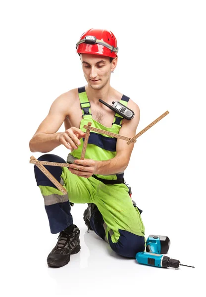 Young handsome contractor holding ruler. Isolated over white background. — Stock Photo, Image