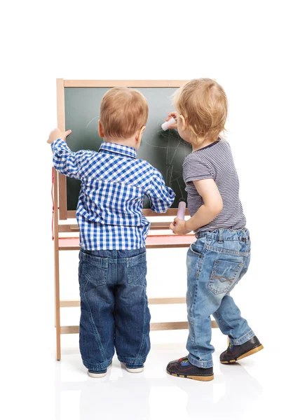 Toddler boys drawing on chalkboard over white background — Stock Photo, Image