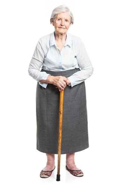 Senior woman with walking stick standing over white — Stock Photo, Image