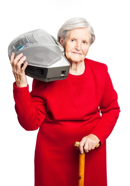 Mujer mayor escuchando música mientras lleva grabadora estéreo sobre blanco — Foto de Stock