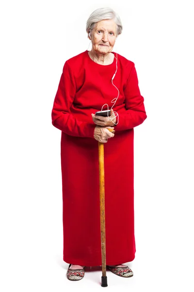 Senior woman listening to music over white background — Stock Photo, Image