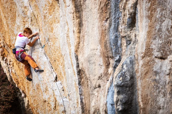 Jonge vrouwelijke rock klimmer op een rotswand — Stockfoto