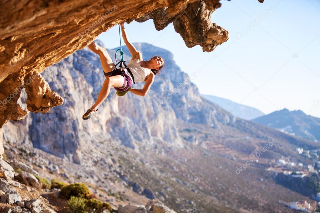 Young female rock climber on a cliff