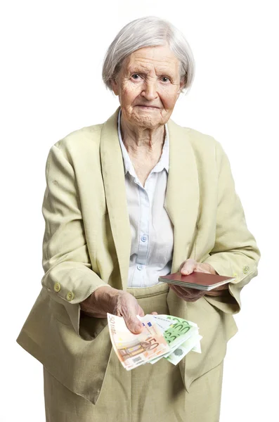 Senior woman giving money and holding passport, face in focus. Isolated over white. — Stock Photo, Image