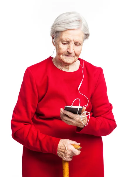 Senior mulher ouvindo música sobre fundo branco — Fotografia de Stock