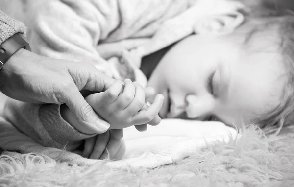 Vista de cerca de la madre sosteniendo la mano del hijo mientras duerme —  Fotos de Stock