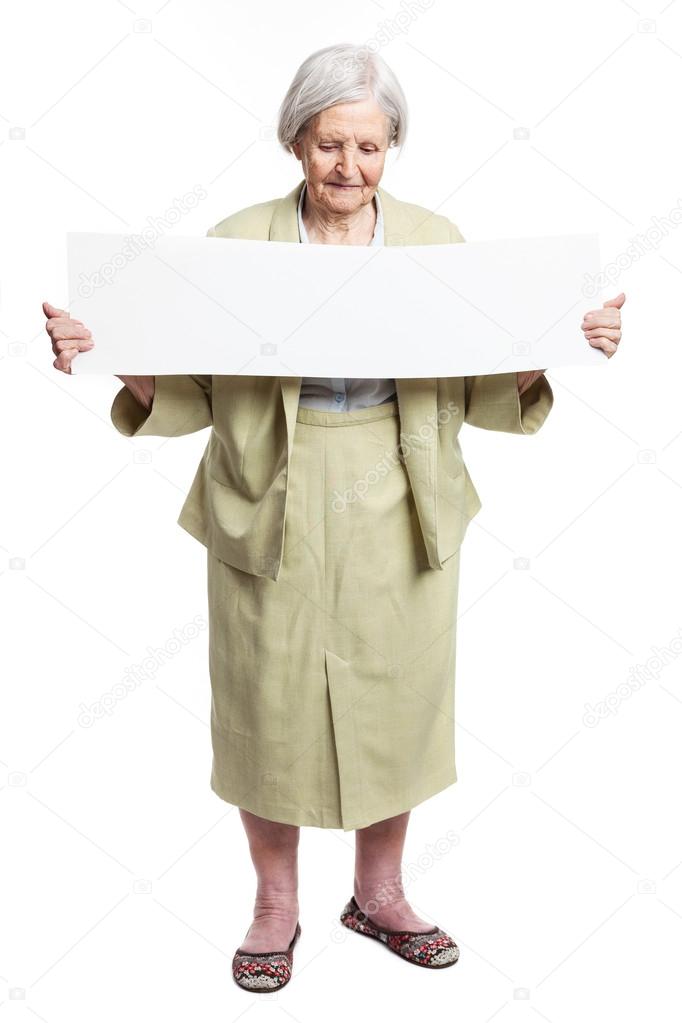 Happy elderly lady holding blank sheet in hands over white
