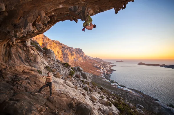 Scalatore di roccia maschio che arrampica su un tetto in una grotta — Foto Stock