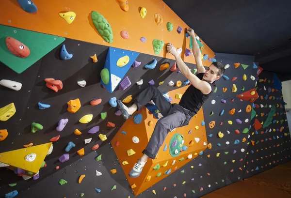 Mann übt Bouldern in Kletterhalle — Stockfoto